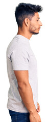 Handsome latin american young man wearing casual tshirt looking to side, relax profile pose with natural face with confident smile.
