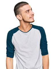 Obraz premium Hispanic young man wearing casual clothes looking away to side with smile on face, natural expression. laughing confident.