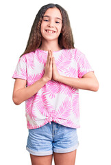 Cute hispanic child girl wearing casual clothes praying with hands together asking for forgiveness smiling confident.