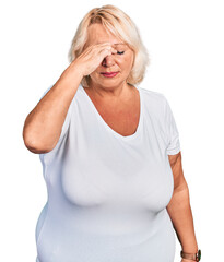 Middle age blonde woman wearing casual white t shirt tired rubbing nose and eyes feeling fatigue and headache. stress and frustration concept.