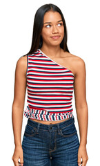 Fototapeta premium Beautiful hispanic woman wearing casual clothes smiling looking to the side and staring away thinking.