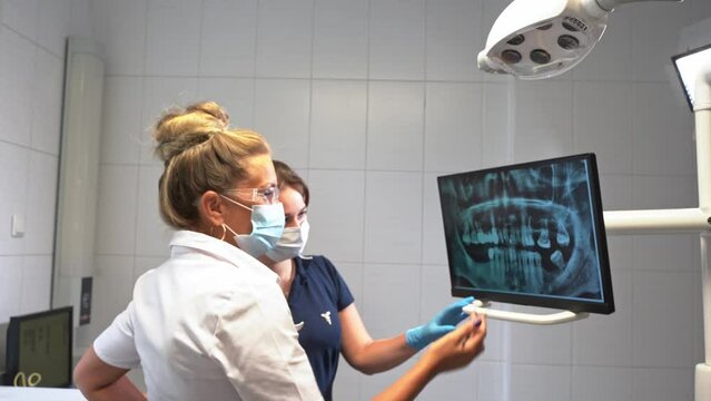 Dentist hand explore study teeth mouth cavity x-ray on monitor describe therapy to patient at dentistry office over. Oral hygiene orthodontic treatment, examination of health tooth care