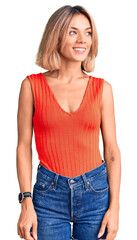 Fototapeta premium Beautiful caucasian woman wearing casual clothes looking away to side with smile on face, natural expression. laughing confident.