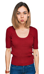 Obraz premium Young blonde girl wearing casual clothes puffing cheeks with funny face. mouth inflated with air, crazy expression.