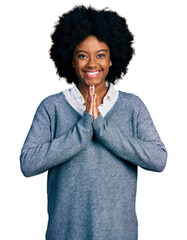 Young african american woman wearing business clothes praying with hands together asking for forgiveness smiling confident.