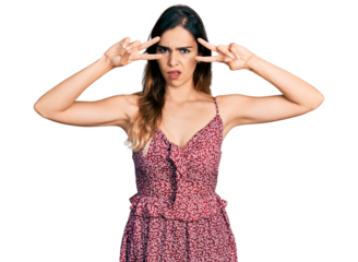 Beautiful hispanic woman wearing bohemian and hippie style doing peace symbol in shock face, looking skeptical and sarcastic, surprised with open mouth