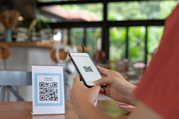 Woman use smartphone to scan QR code for order menu in cafe restaurant with a digital delivery. Choose menu and order accumulate discount. E wallet, technology, pay online, credit card, bank app. - obrazy, fototapety, plakaty