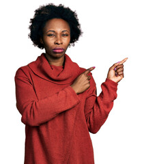 African american woman with afro hair pointing with fingers to the side skeptic and nervous, frowning upset because of problem. negative person.