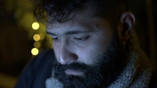 A beard student looking deeply into a laptop screen studying or writing a book