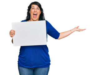 Plus size brunette woman holding blank empty banner smiling happy and positive, thumb up doing excellent and approval sign