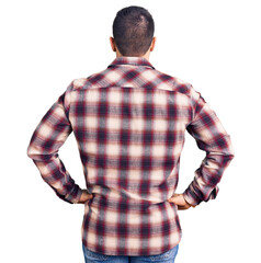 Young handsome man wearing casual shirt standing backwards looking away with arms on body