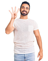 Young hispanic man wearing casual clothes showing and pointing up with fingers number four while smiling confident and happy.