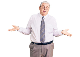 Senior grey-haired man wearing business clothes clueless and confused expression with arms and...