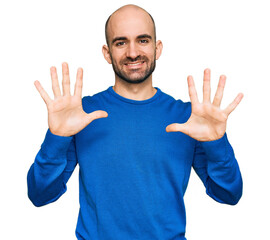 Young hispanic man wearing casual clothes showing and pointing up with fingers number ten while smiling confident and happy.