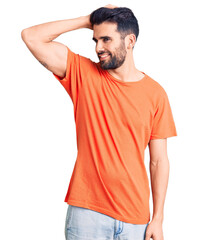 Fototapeta premium Young handsome man with beard wearing casual t-shirt smiling confident touching hair with hand up gesture, posing attractive and fashionable
