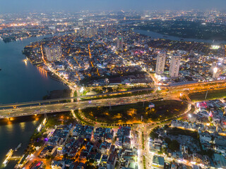 Obraz premium Aerial view of a Ho Chi Minh City, Vietnam with development buildings, transportation, energy power infrastructure. Financial and business centers. Sunset to night.