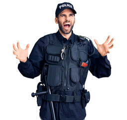 Young handsome man with beard wearing police uniform crazy and mad shouting and yelling with aggressive expression and arms raised. frustration concept.