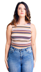 Obraz premium Beautiful young brunette woman wearing casual clothes with serious expression on face. simple and natural looking at the camera.