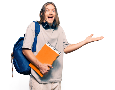 Handsome caucasian man with long hair wearing student backpack and holding books celebrating victory with happy smile and winner expression with raised hands
