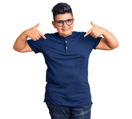 Little boy kid wearing casual clothes and glasses looking confident with smile on face, pointing...