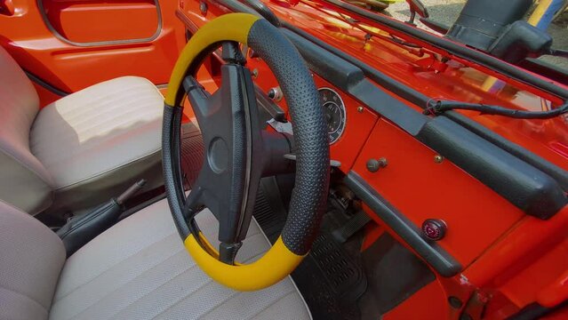 Close up shot of steering wheel car of a classic car Volkswagen Type 181,182 or Kurierwagen or Trekker. Driver's cabin Red color of Volkswagen car - Car interior