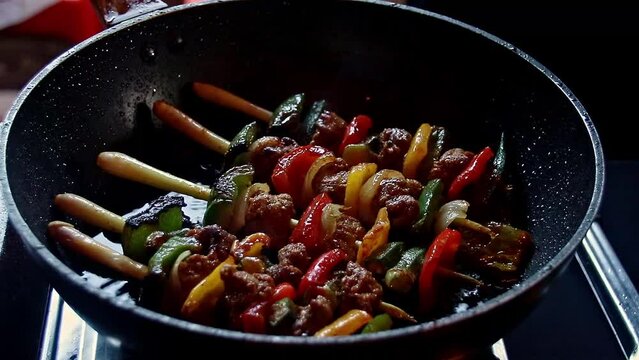 Cambodian beef kebabs using lemongrass for stick or sach ko ang frying on a pan, authentic khmer local dish