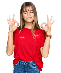 Teenager caucasian girl wearing casual red t shirt relaxed and smiling with eyes closed doing meditation gesture with fingers. yoga concept.