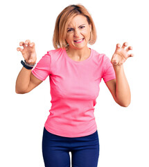 Obraz premium Young blonde woman wearing sportswear smiling funny doing claw gesture as cat, aggressive and sexy expression