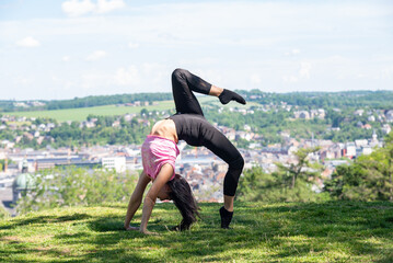 Young woman making yoga near the city