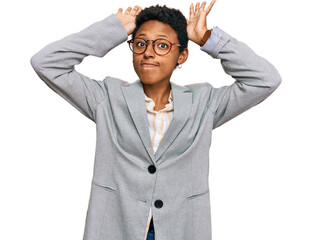 Young african american woman wearing business clothes doing bunny ears gesture with hands palms...