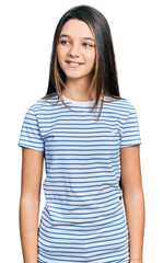 Fototapeta premium Young brunette girl with long hair wearing casual striped t shirt looking to side, relax profile pose with natural face and confident smile.