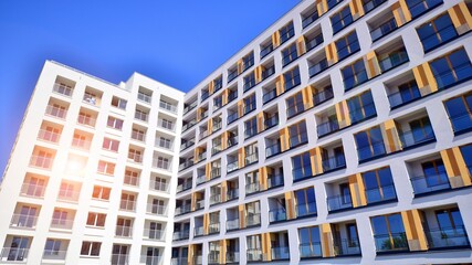 Contemporary residential building exterior in the daylight. Modern apartment buildings on a sunny day with a blue sky. Facade of a modern apartment building. 