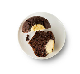 Muffin de chocolate relleno de crema cortado, vista cenital. Chocolate muffin filled with cream cut, overhead view.