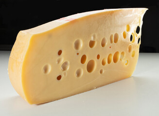 Queso gruyer,  sobre fondo negro. Gruyère cheese, on a black background.