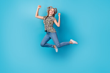 Fototapeta na wymiar Full size photo of pleasant ecstatic woman dressed zebra shirt jeans white sneakers jumping win betting isolated on blue color background