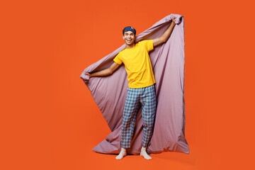 Full body cheerful happy young man wears pyjamas jam sleep eye mask rest relax at home look camera...