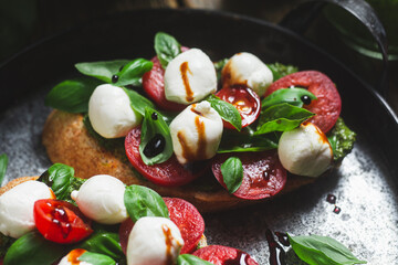 Bruschetta with mozzarella, tomatoes, basil and pesto in a plate. Bruschetta Caprese
