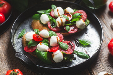 Bruschetta with mozzarella, tomatoes, basil and pesto in a plate. Bruschetta Caprese