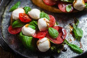Bruschetta with mozzarella, tomatoes, basil and pesto in a plate. Bruschetta Caprese