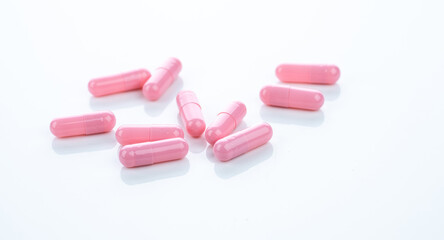 Obraz na płótnie Canvas Pink capsule pills on white background. Pharmaceutical industry. Vitamins, minerals, and supplements concept. Pharmacy products. Pharmaceutical medicine. Prescription drugs. Healthcare and medicine.