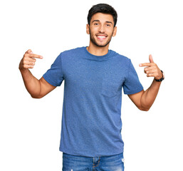 Young handsome man wearing casual clothes looking confident with smile on face, pointing oneself...