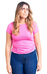 Fototapeta premium Young caucasian woman wearing sportswear puffing cheeks with funny face. mouth inflated with air, crazy expression.