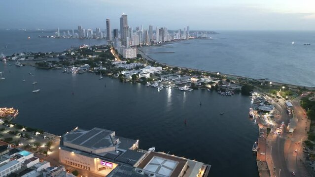 Cartagena Colombia aerial cityscape with Caribbean Sea at sunset illuminated with contrast between old historical downtown and modern skyscraper building drone footage 