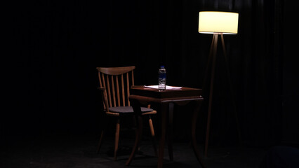 table, chair and floor lamp under spotlight