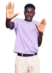 Fototapeta premium Young african american man wearing casual clothes afraid and terrified with fear expression stop gesture with hands, shouting in shock. panic concept.