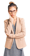 Beautiful caucasian woman with blonde hair wearing business jacket and glasses thinking looking...