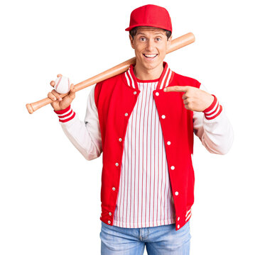 Young handsome man playing baseball holding bat and ball smiling happy pointing with hand and finger