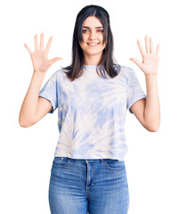Young beautiful girl wearing casual t shirt showing and pointing up with fingers number ten while smiling confident and happy.