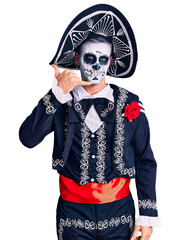 Young man wearing day of the dead costume over background smiling doing phone gesture with hand and fingers like talking on the telephone. communicating concepts.