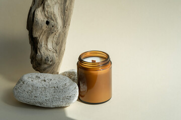 Scented candle in a brown glass jar on wood texture. Home decor, aroma therapy rest relaxation...